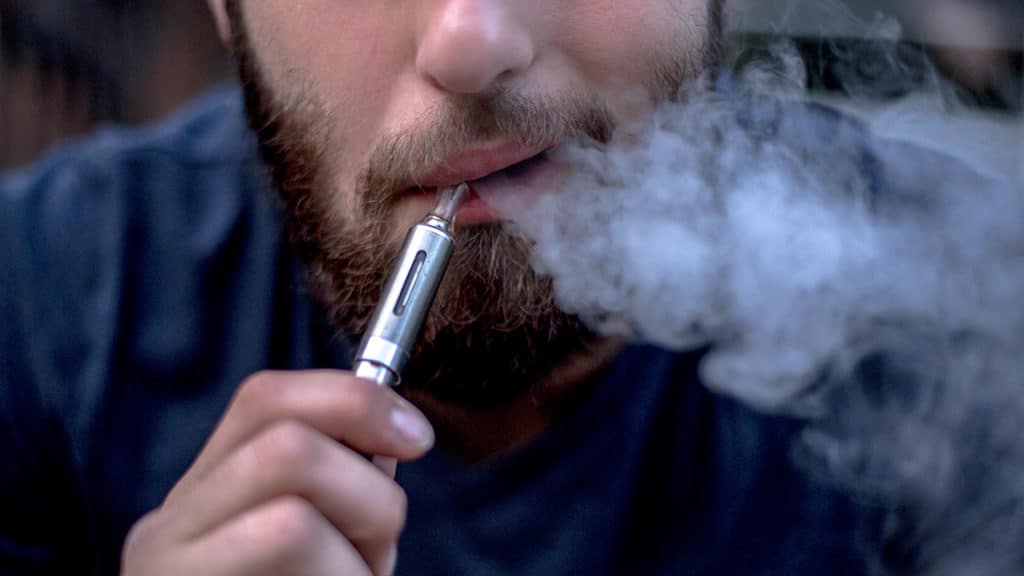 Man Exhaling Vapour from E-Cigarette Using Nic Salts Vape Juice