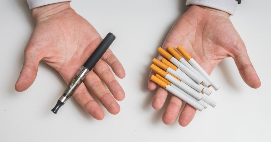 ecigarette and cigarettes in someones hand